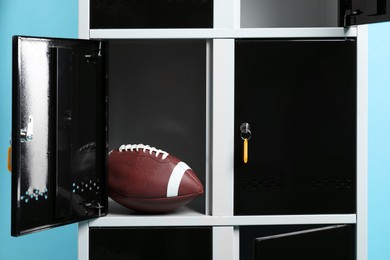 Photo of Open locker with american football ball on light blue background