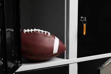 Photo of Open locker with american football ball, closeup