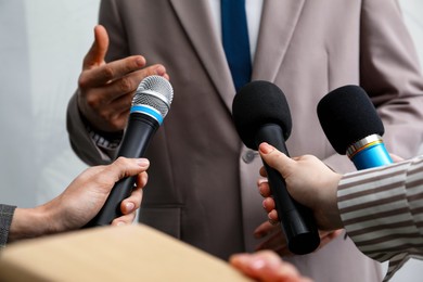 Photo of Group of journalists interviewing businessman indoors, closeup