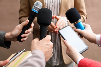 Photo of Group of journalists interviewing businesswoman on beige background, closeup