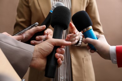 Photo of Group of journalists interviewing businesswoman on beige background, closeup