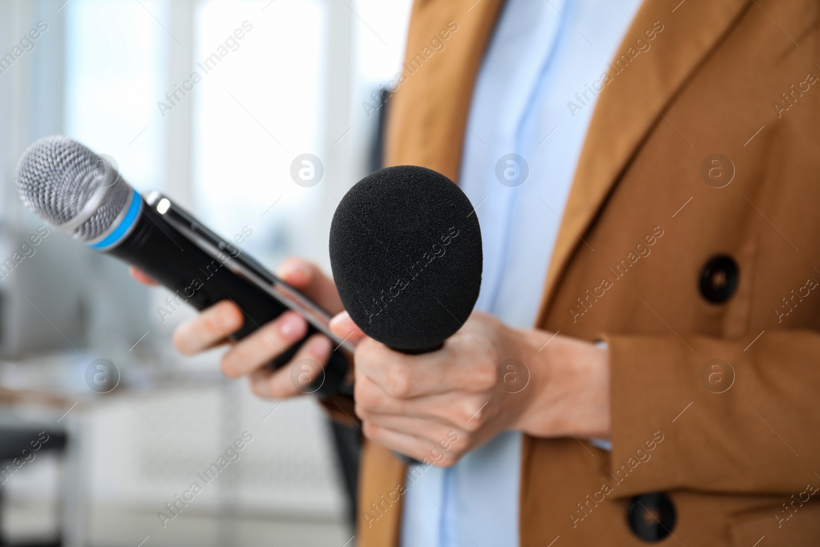 Photo of Journalist with microphones and smartphone indoors, closeup