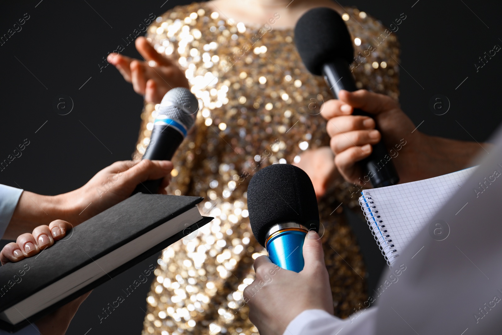 Photo of Group of journalists interviewing celebrity on black background, closeup