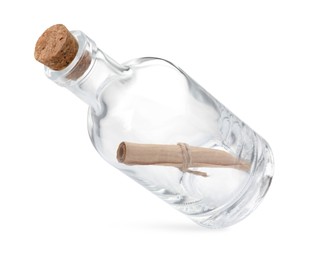 Photo of Corked glass bottle with rolled letter in air isolated on white