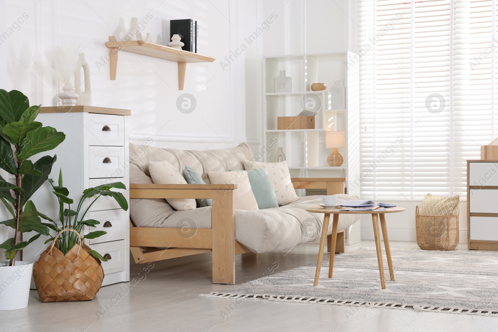 Photo of Beautiful sofa with cushions and coffee table in living room. Interior design