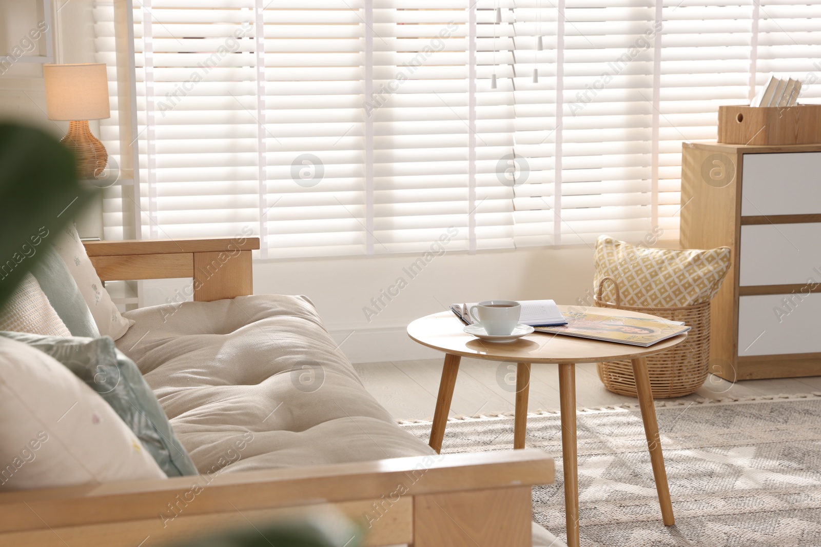 Photo of Beautiful sofa with cushions and coffee table in living room. Interior design