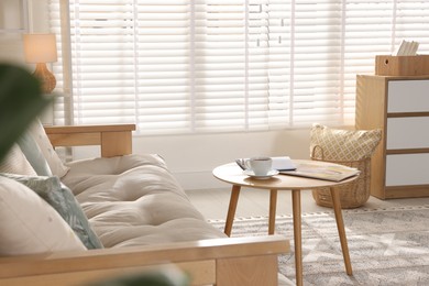 Photo of Beautiful sofa with cushions and coffee table in living room. Interior design