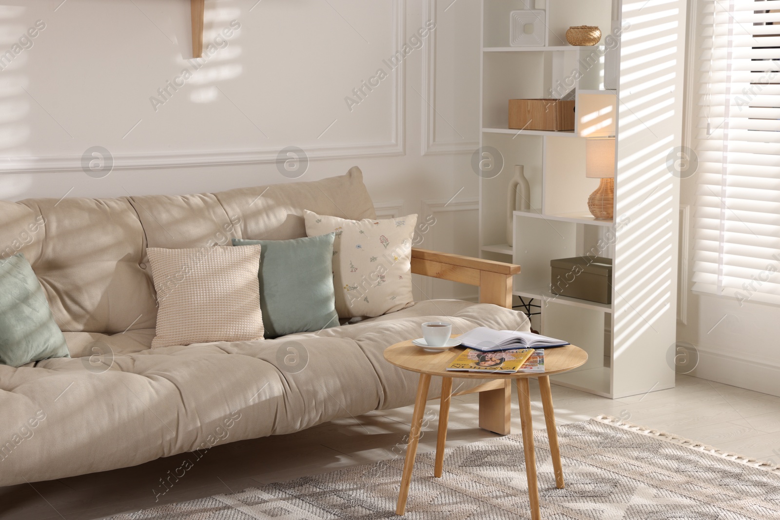 Photo of Beautiful sofa with cushions and coffee table in living room. Interior design