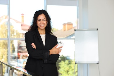 Photo of Portrait of young woman with phone wearing stylish suit indoors. Space for text