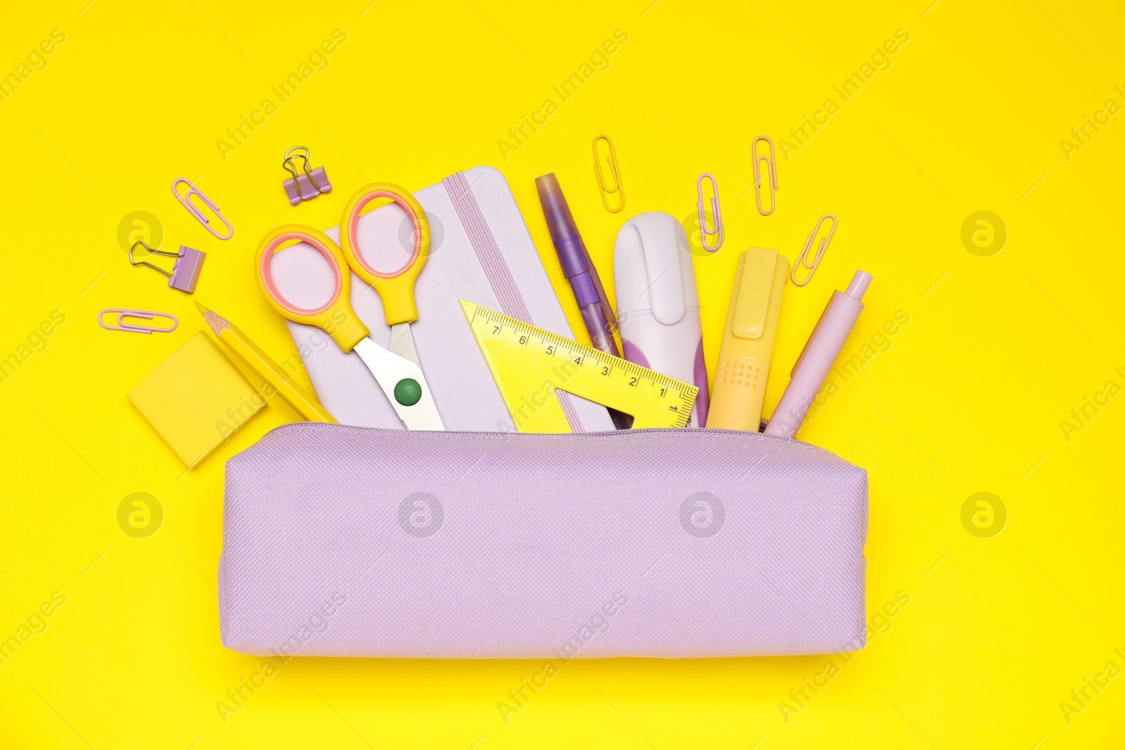 Pencil case and different stationery on yellow background, flat lay Photo of Pencil case and different stationery on yellow background, flat lay
