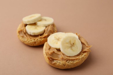 Photo of Tasty sandwiches with peanut butter and banana on brown background, closeup