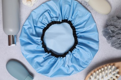 Photo of Shower cap and bath accessories on grey background, flat lay