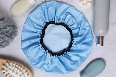 Photo of Shower cap and bath accessories on grey background, flat lay