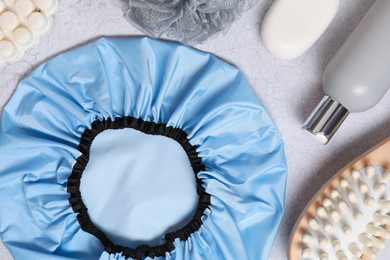 Photo of Shower cap and bath accessories on grey background, flat lay