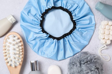 Photo of Shower cap and bath accessories on grey background, flat lay