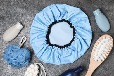 Photo of Shower cap and bath accessories on grey background, flat lay