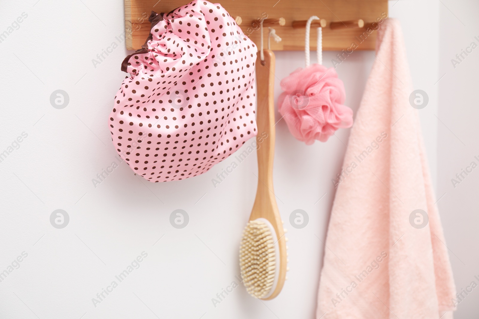 Photo of Shower cap, brush, mesh sponge and towel indoors