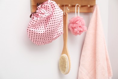 Photo of Shower cap, brush, mesh sponge and towel indoors