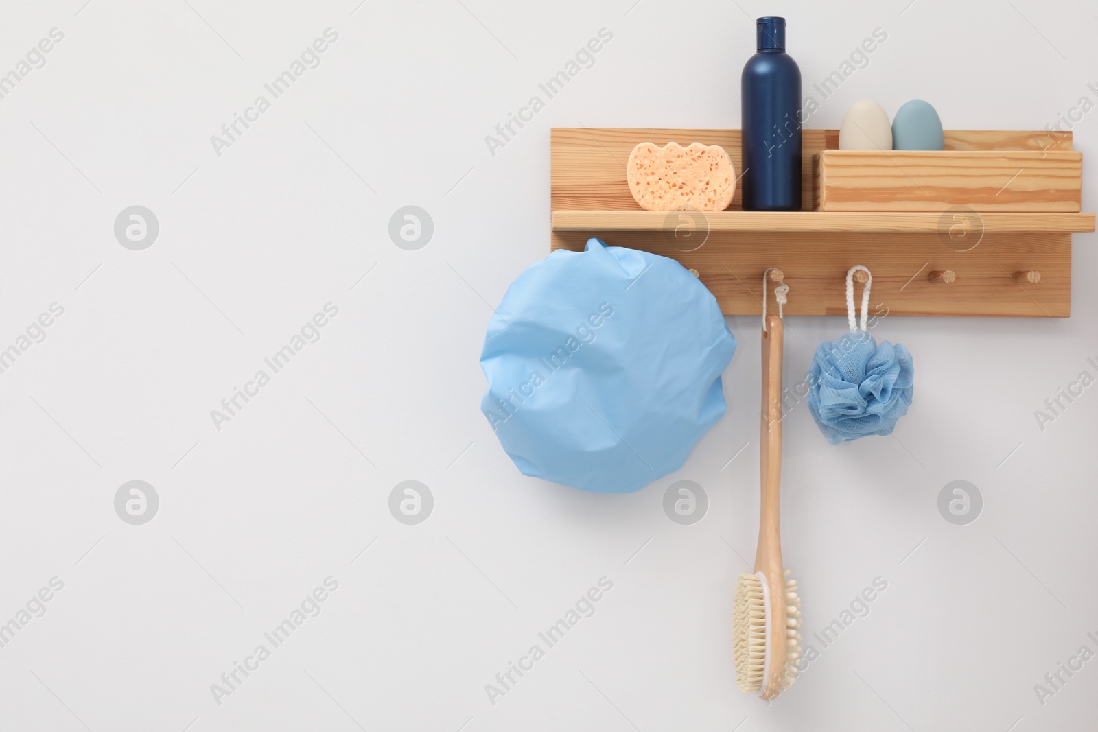 Photo of Shower cap and bath accessories on rack indoors, space for text