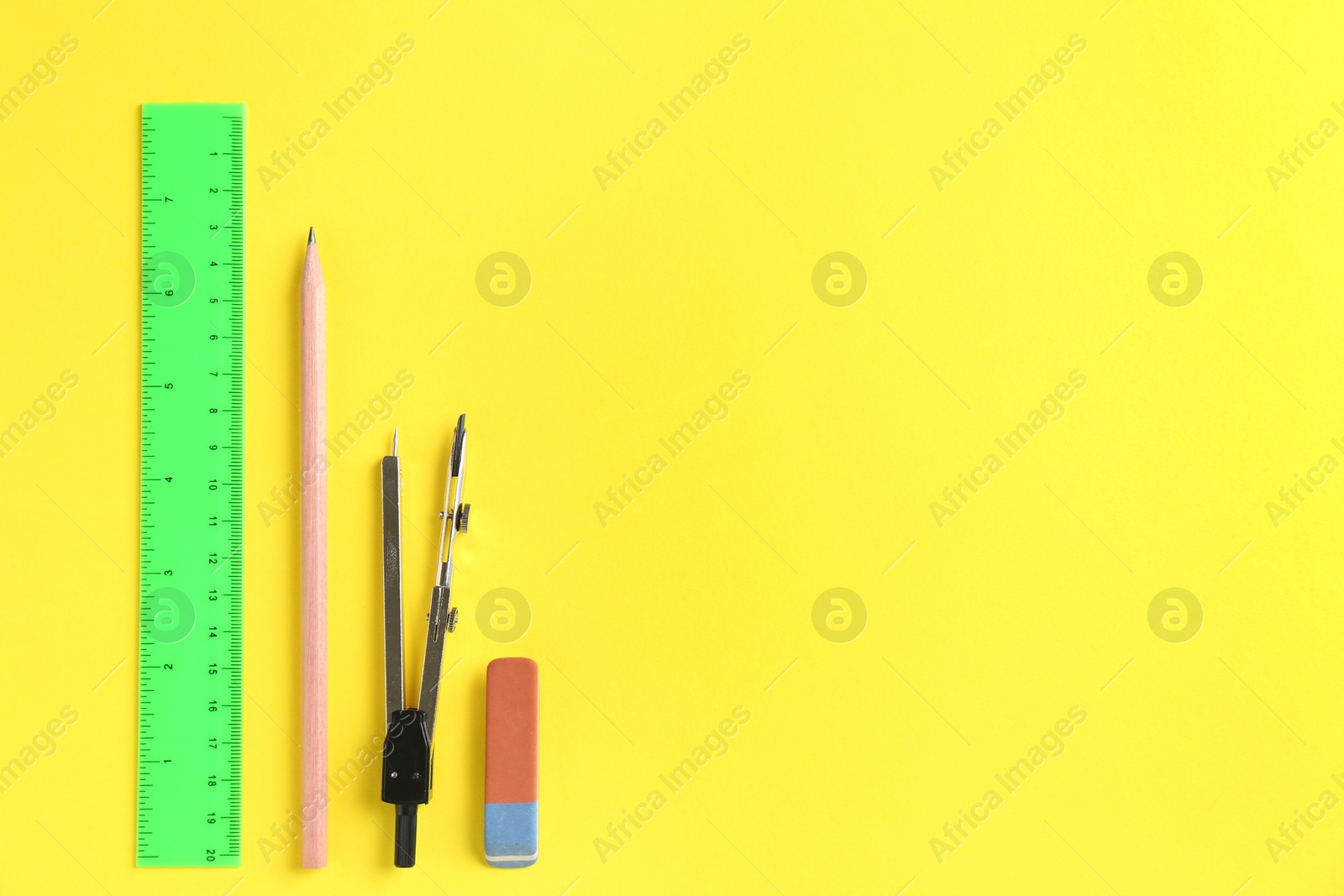 Photo of Flat lay composition with ruler and other stationery on yellow background, space for text