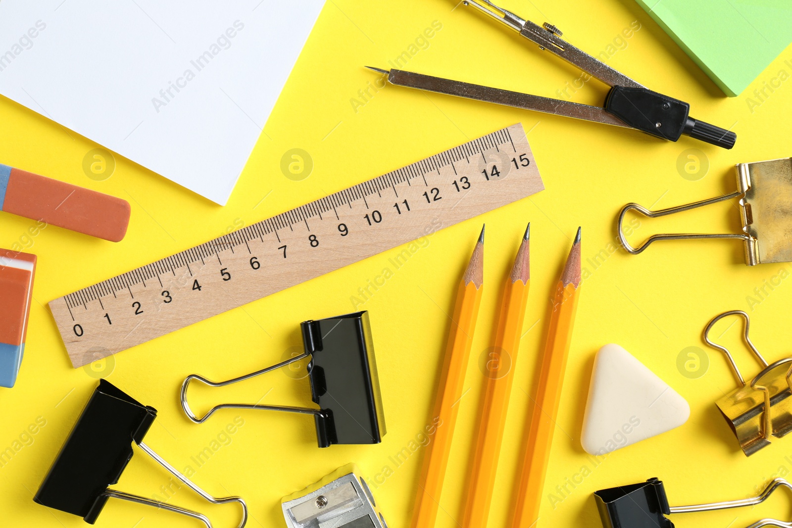 Photo of Flat lay composition with ruler and other stationery on yellow background