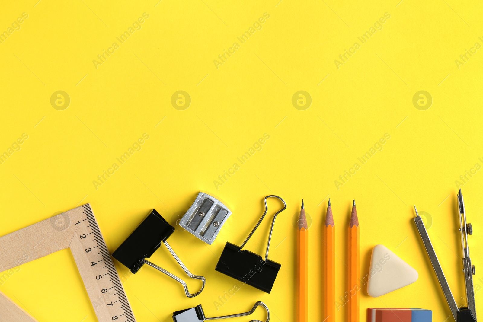 Photo of Flat lay composition with ruler and other stationery on yellow background, space for text