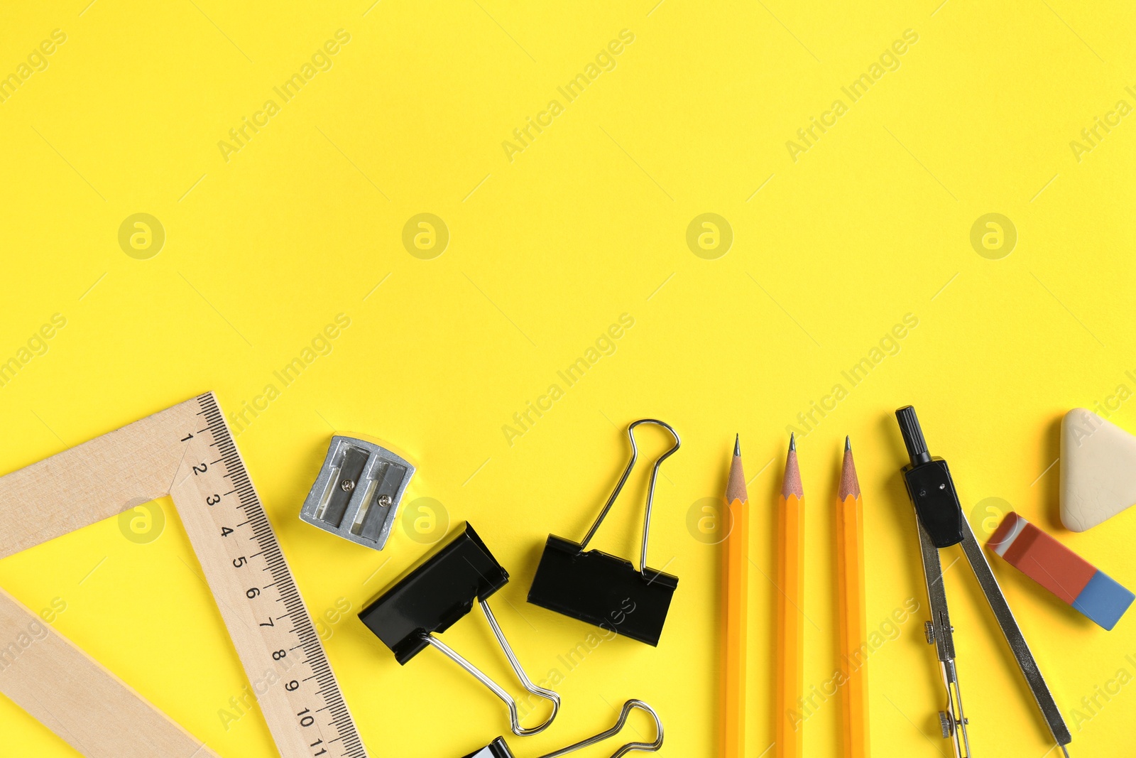 Photo of Flat lay composition with ruler and other stationery on yellow background, space for text