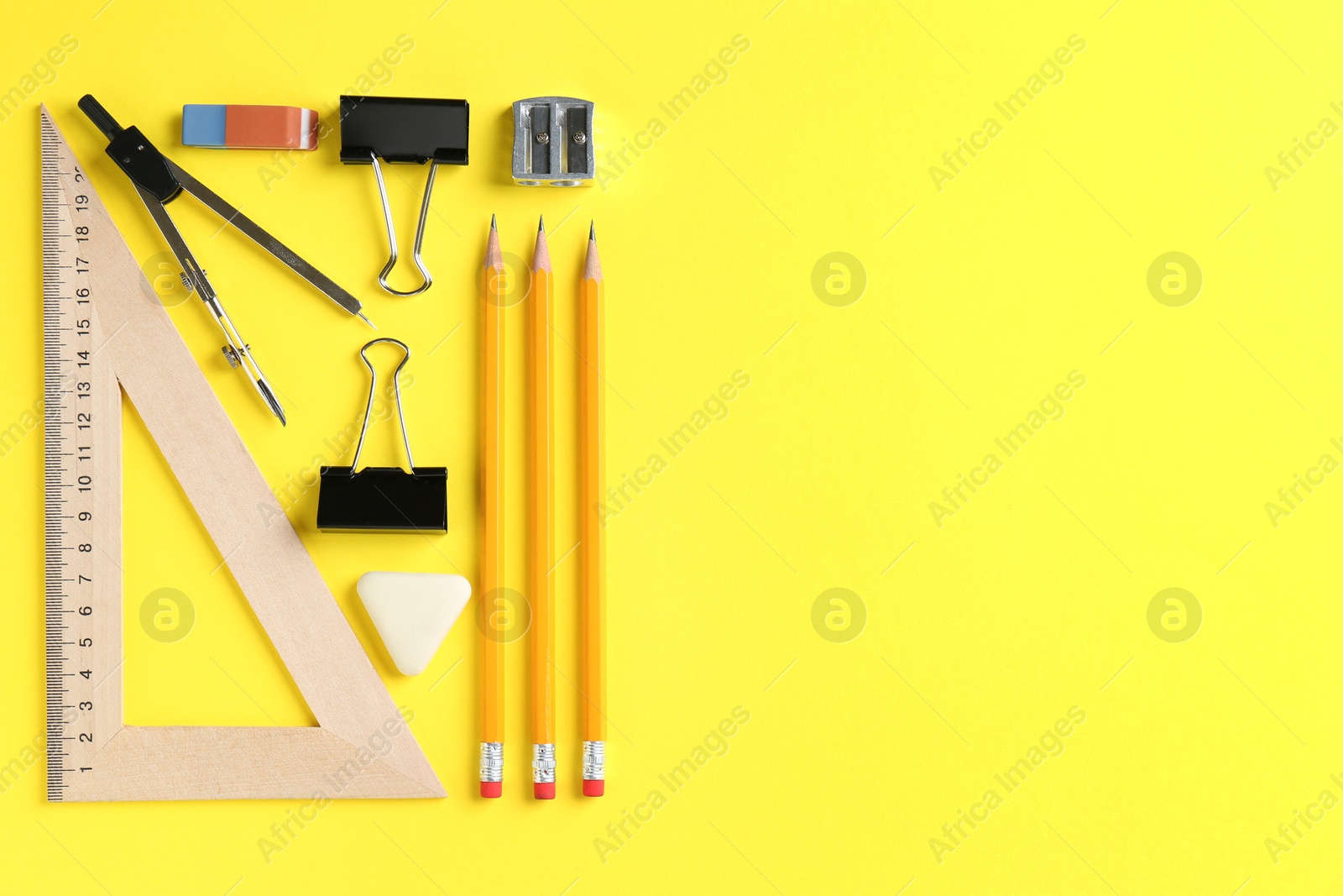 Photo of Flat lay composition with ruler and other stationery on yellow background, space for text