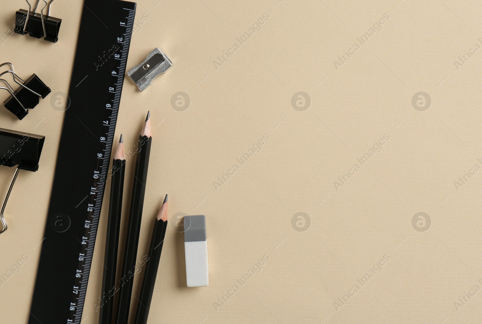 Photo of Flat lay composition with ruler and other stationery on beige background, space for text