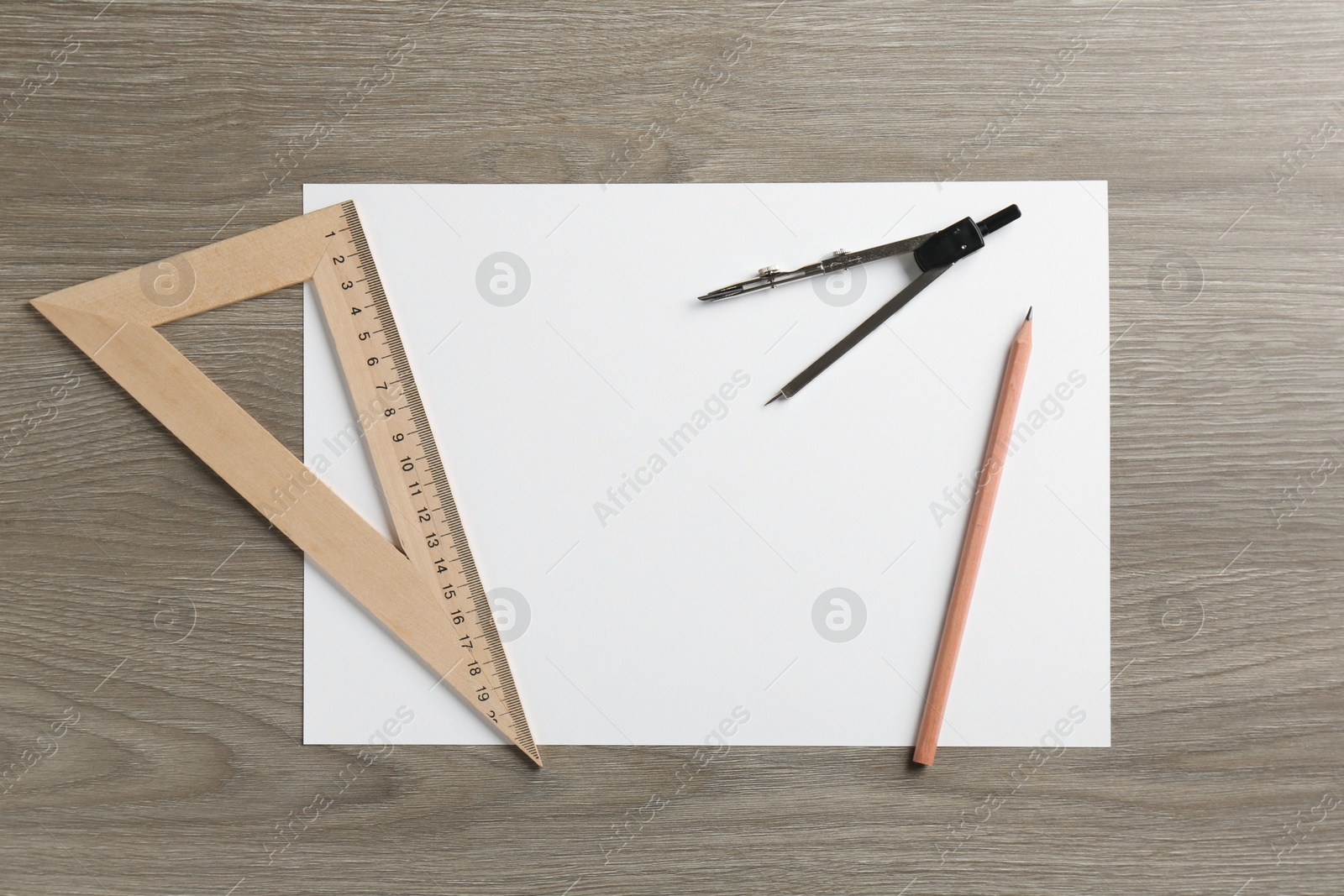 Photo of Paper, ruler, compass and pencil on wooden table, flat lay. Space for text