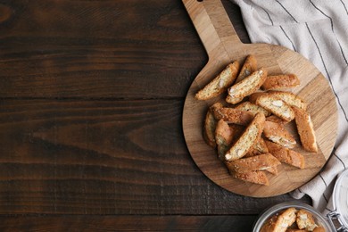 Photo of Traditional Italian almond biscuits (Cantucci) on wooden table, top view. Space for text