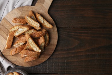 Photo of Traditional Italian almond biscuits (Cantucci) on wooden table, top view. Space for text