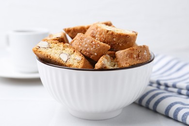 Photo of Traditional Italian almond biscuits (Cantucci) in bowl on white table, closeup