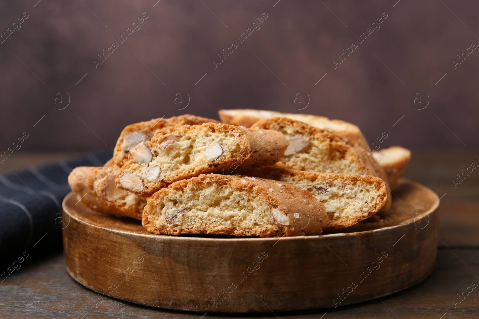 Photo of Tasty almond biscuits (Cantuccini) on wooden table, closeup