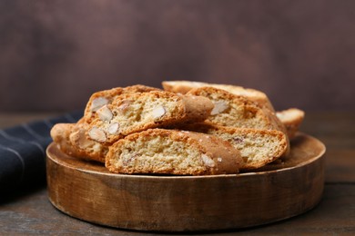 Photo of Tasty almond biscuits (Cantuccini) on wooden table, closeup