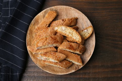 Photo of Tasty almond biscuits (Cantuccini) on wooden table, top view