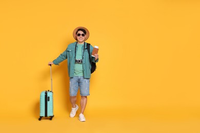 Photo of Traveller with passport and suitcase on yellow background. Space for text