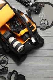 Photo of Professional photographer's equipment and backpack on grey wooden background, flat lay