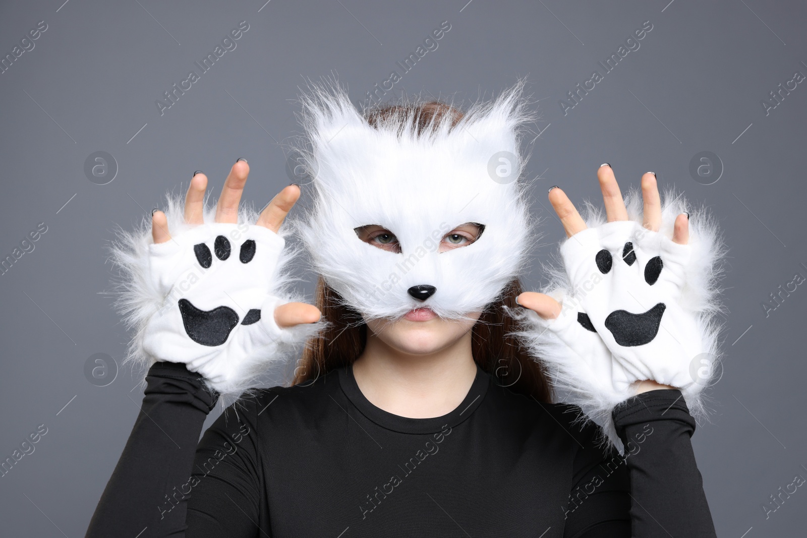 Photo of Quadrobics. Girl wearing cat mask and gloves on grey background