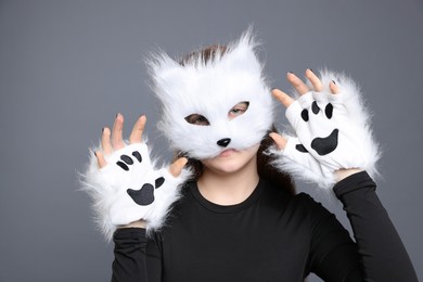 Photo of Quadrobics. Girl wearing cat mask and gloves on grey background