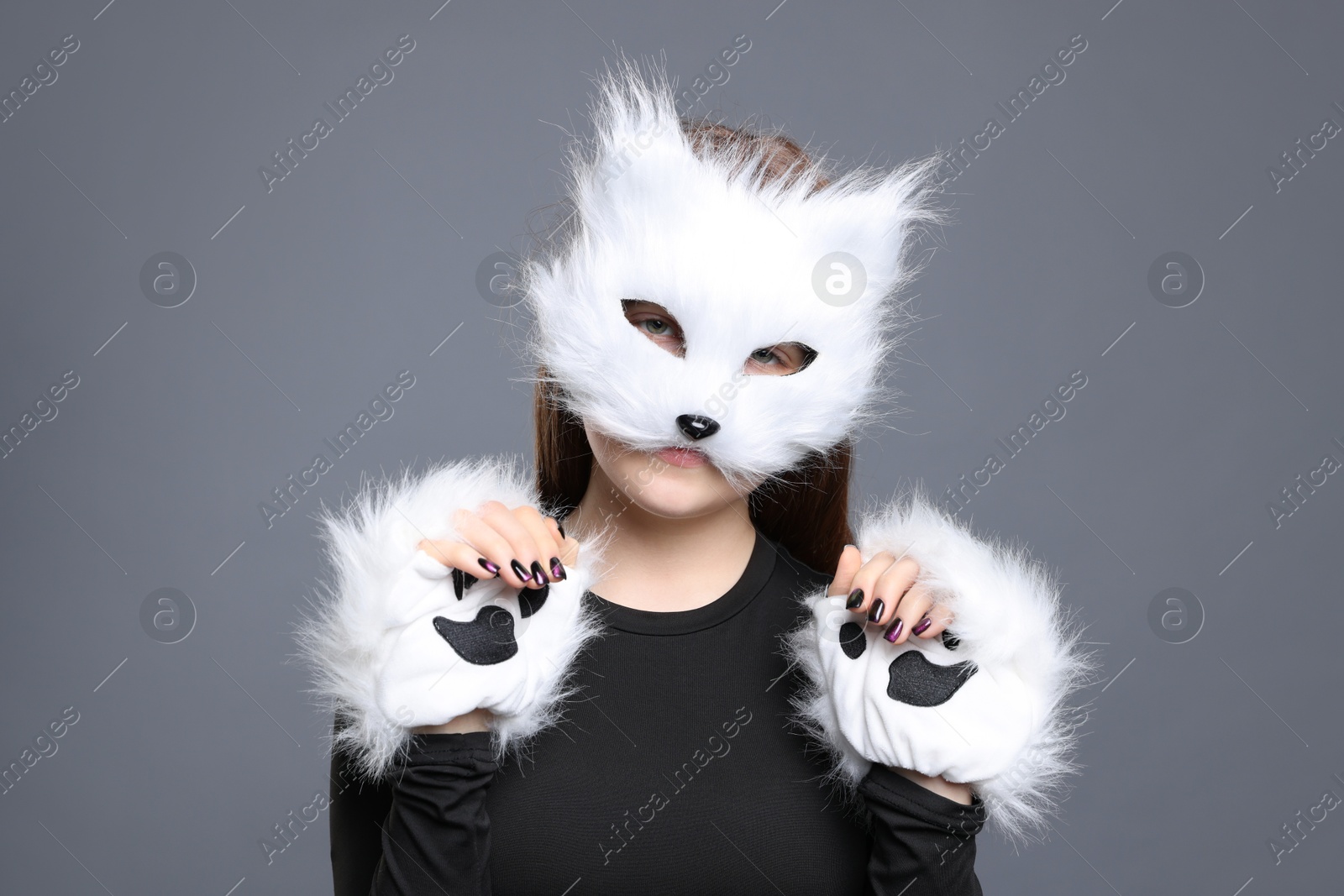 Photo of Quadrobics. Girl wearing cat mask and gloves on grey background