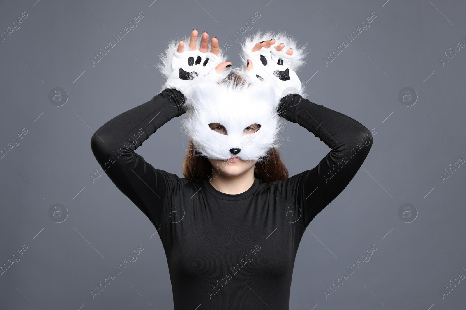 Photo of Quadrobics. Girl wearing cat mask and gloves on grey background