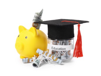 Photo of Piggy bank, graduate hat, dollar banknotes and glass jar with word Education isolated on white. Tuition payment