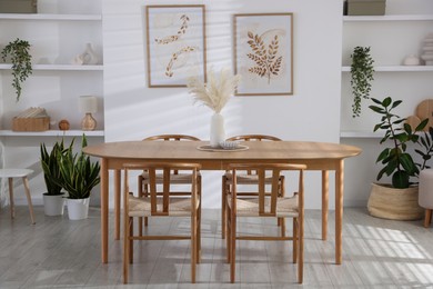 Photo of Stylish wooden table with chairs and decor indoors. Interior design