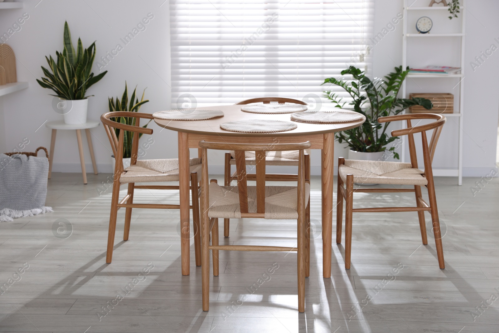 Photo of Stylish wooden table with chairs and decor indoors. Interior design