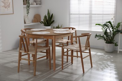 Photo of Stylish wooden table with chairs and decor indoors. Interior design