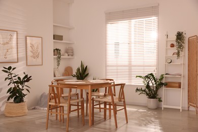 Photo of Stylish wooden table with chairs and decor indoors. Interior design