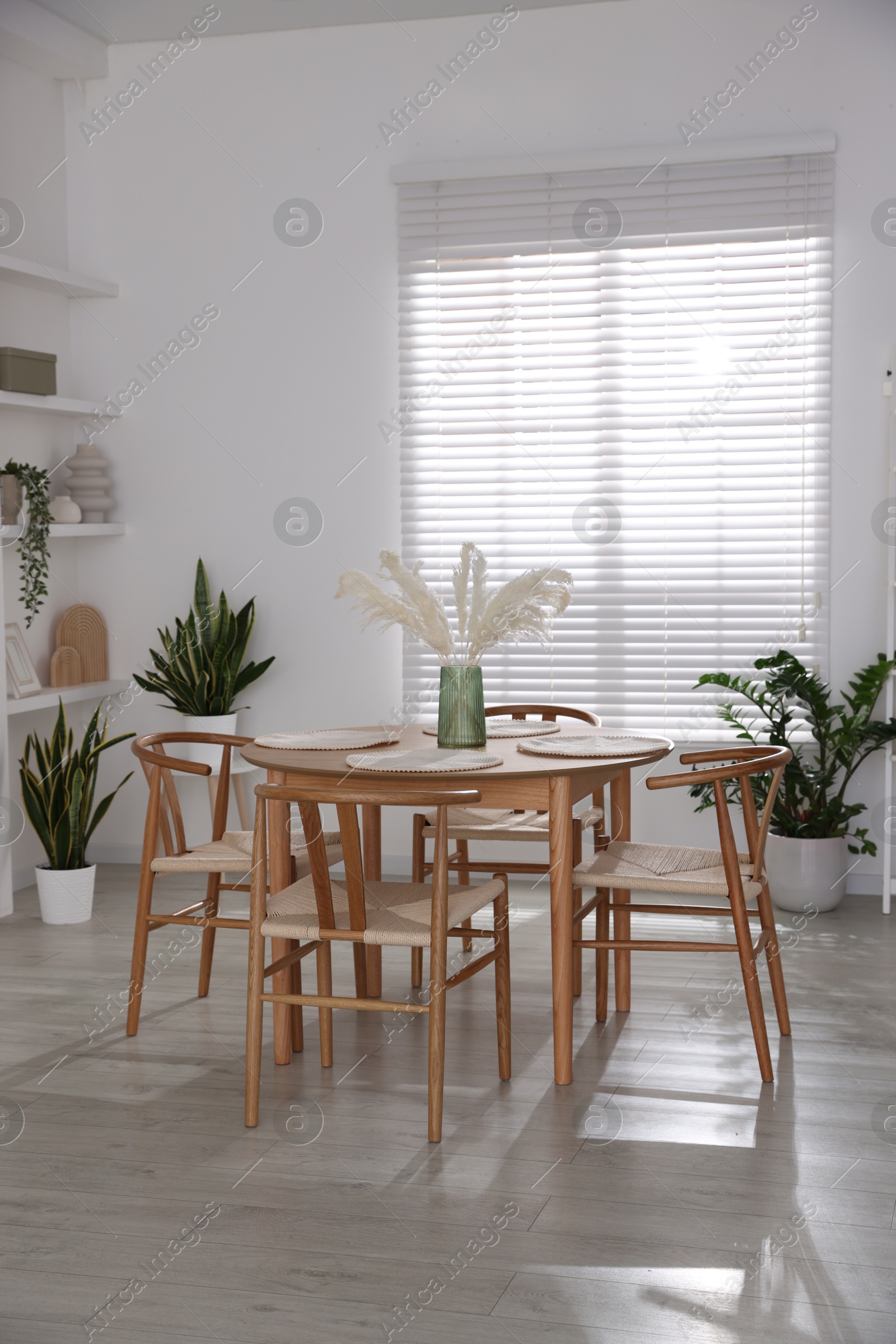 Photo of Stylish wooden table with chairs and decor indoors. Interior design