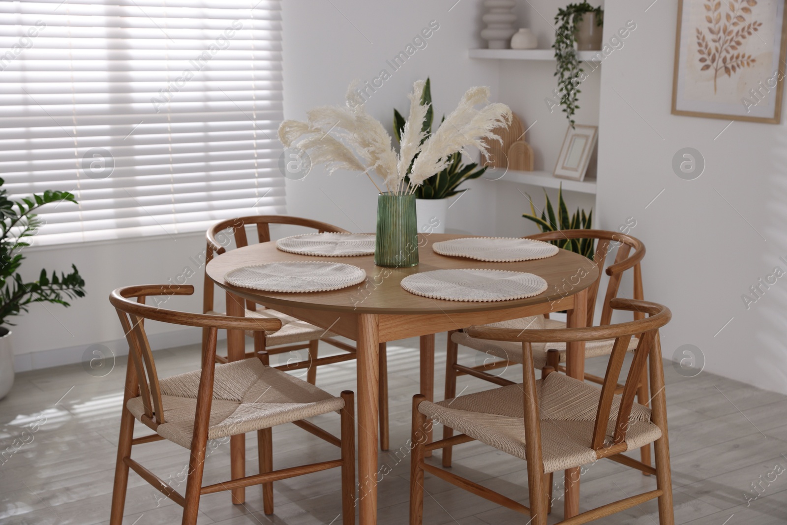 Photo of Stylish wooden table with chairs and decor indoors. Interior design