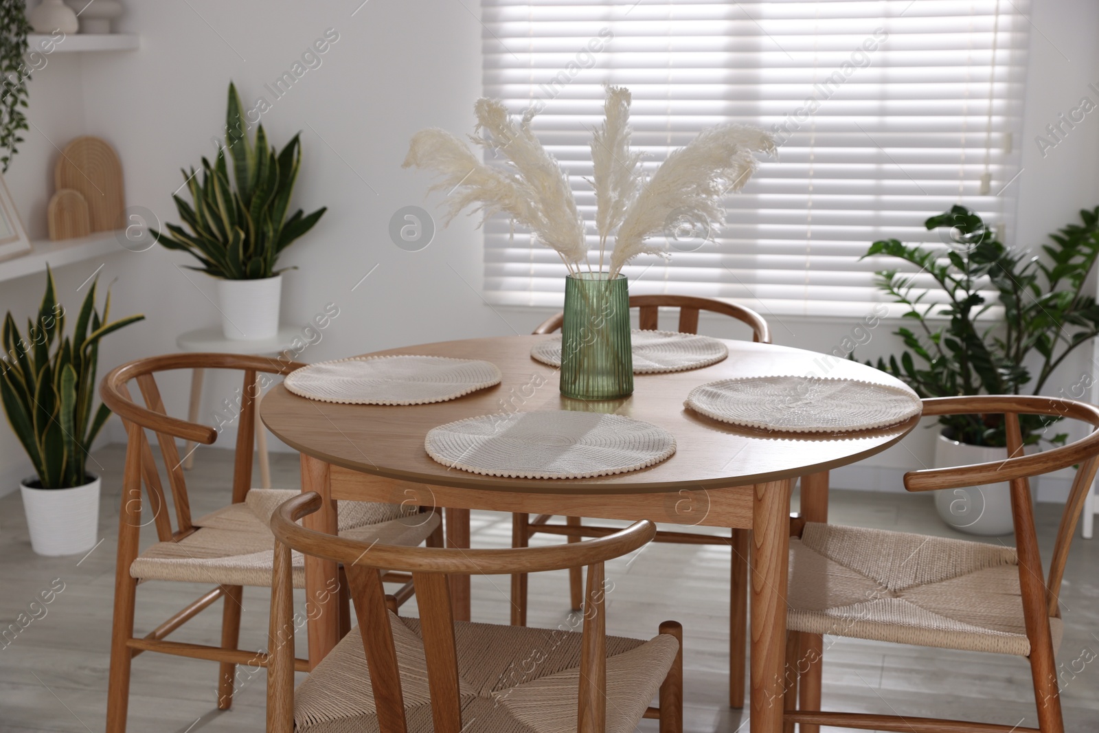 Photo of Stylish wooden table with chairs and decor indoors. Interior design